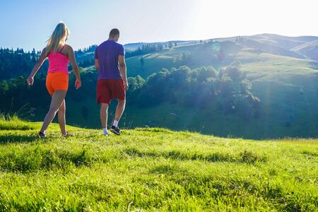 Running fitness couple of runners doing sport on road outdoor. Active living man and woman jogging training cardio in summer outdoors nature.の写真素材