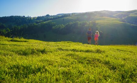 Running fitness couple of runners doing sport on road outdoor. Active living man and woman jogging training cardio in summer outdoors nature.の写真素材