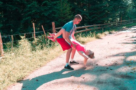 Young sports couple doing exercises in forestの写真素材