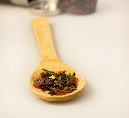 Green tea with berries on wooden spoonの写真素材