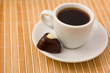 Coffee in white cup and chocolate- heart の写真素材