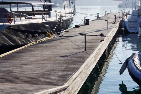 Wooden pier with boats moored at sunice の写真素材