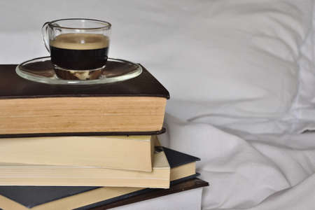 Cup of coffe with books in bedの写真素材