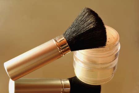 Face powder with brush and Their reflection in the mirror