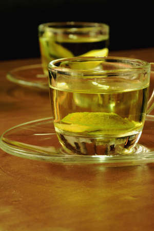 Two glasses with lemon tea on a wooden surfaceの写真素材