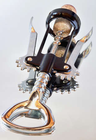 Corkscrew for wine with the cork and Their reflection in the mirror