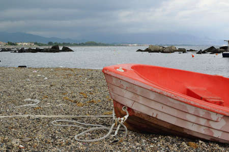 Old red boat on the shoreの写真素材