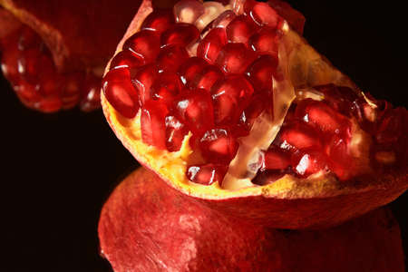 Slice of pomegranate reflection on the surfaceの写真素材
