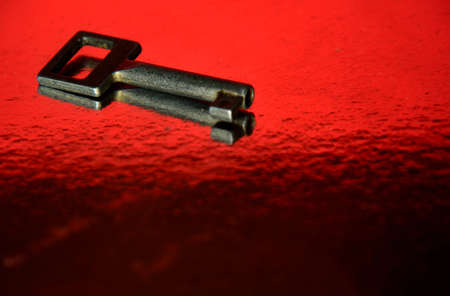 Iron key on a red black surfaceの写真素材
