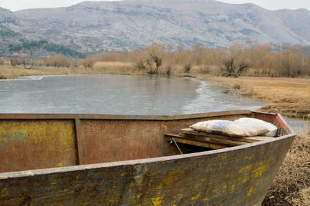 Old fishing boat on the shore of the lakeの写真素材