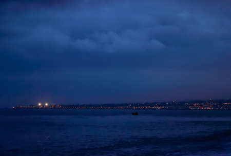 Night cityscape view on the shore of the seaの写真素材