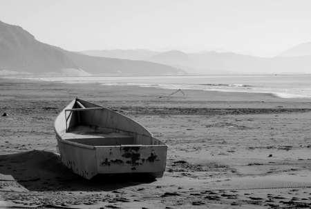 Black white image of a boat on the sea shore after the stormの写真素材