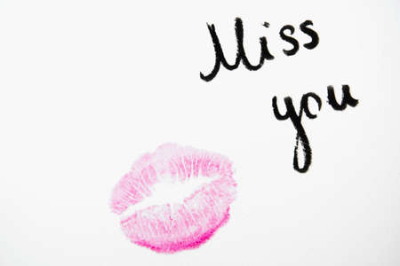 "Miss you" text with lipstick kiss on white backgroundの写真素材