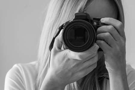 Young woman is photographed with digital cameraの写真素材