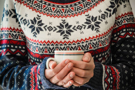 Woman with winter dress holds a coffee mugの写真素材