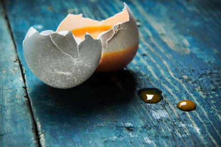 One broken egg on a wooden tableの写真素材