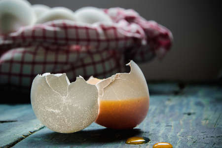 One broken egg on a wooden table