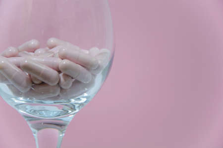 Pink pills in the glass. Concepts - abuse of medicines, dependenceの写真素材