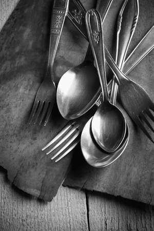 Detail of vintage cutlery on wooden tableの写真素材