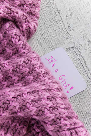 Baby shower It's a girl, celebration card on a cozy pink blanket with space for text. New arrival in...