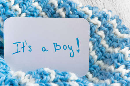 "It's a boy" baby shower, announcement card on cozy woolen blanket and space for text. New arrival in the familyの写真素材