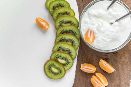 Top view of fresh fruits and yogurt for breakfast or snack with space for text. Healthy eating...