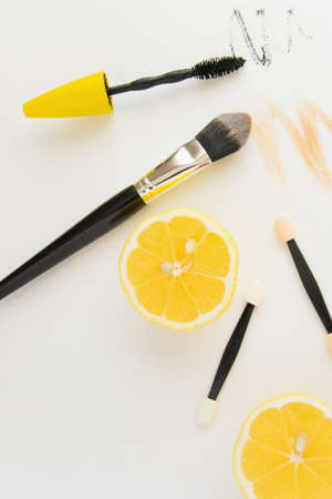 Top view of modern fashion flat lay, fashion workspace with cosmetics and fresh lemons on white background and space for textの写真素材