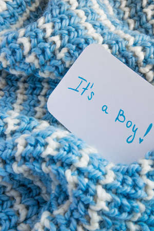 "It's a boy" baby shower, announcement card on cozy woolen blanket and space for text. New arrival in the familyの写真素材