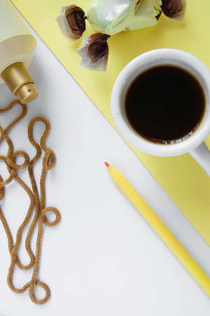 Top view of women's business work desk. Fresh flat lay feminine workspace with cup of coffee,...