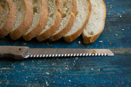 Top view of fresh homemade bread cut into slices on rustic blue table with space for textの写真素材