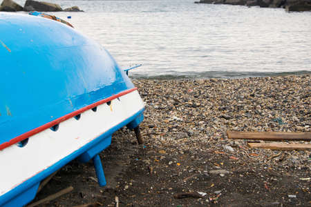 Traditional wooden turned fishing boat on the seashoreの写真素材