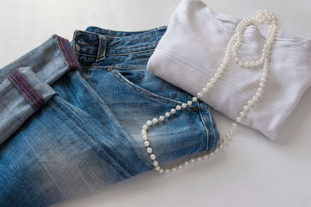 Women's fashionable casual outfit - blue jeans, white sweater and white pearl necklaceの写真素材