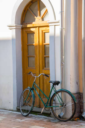 Old bicycle in front of the house door, traditional mode of transportation for healthy lifeの写真素材