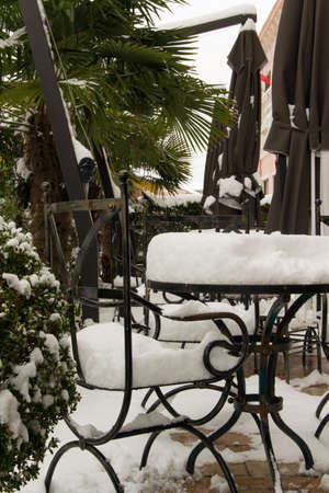 Tables and chairs of cafe bar, covered with snowの写真素材
