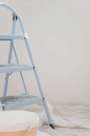 Indoor view of construction site, ladder in foreground and fresh painting/renovation walls with white colorの写真素材