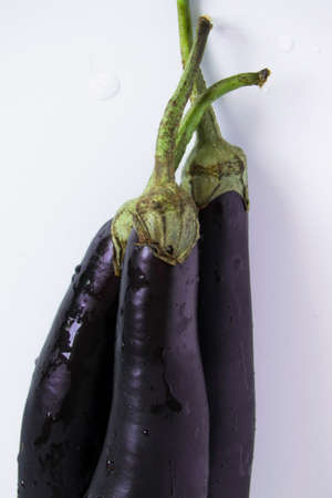 Top view of whole raw violet eggplants on white background, healthy eating, vegetarian concept