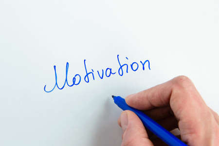 Woman hand writing the word "Motivation" on white backgroundの写真素材