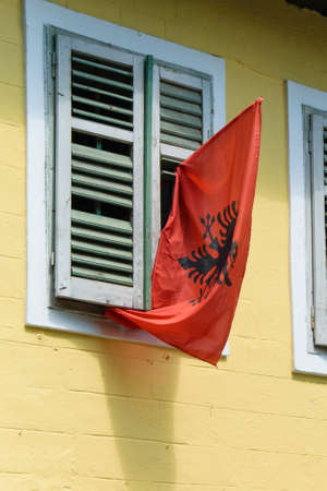 Traditional antique albanian house with the national flag on the windowsの写真素材