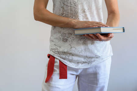 Crop view of young adult woman holding a book