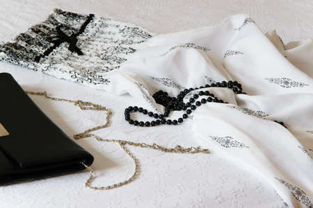 Long elegant dress, hand bag and pearl neck on the bed, fashion celebration conceptの写真素材