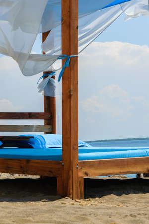 Luxury and romantic bed on the seashore for relaxing time (holidays/vacations), white fluffy clouds in the backgroundの写真素材