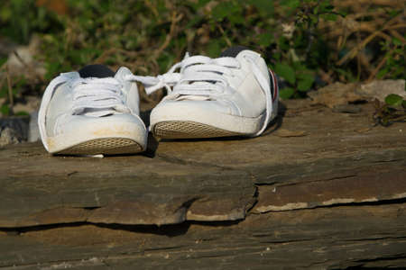 Isolated white sneakers on mountain rock backgroundの写真素材