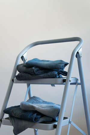 Several pairs of jeans on a ladder, fasion-industry conceptの写真素材
