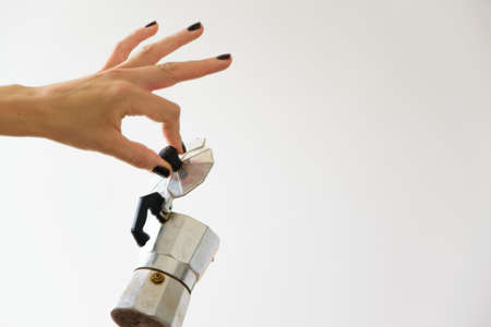Isolated woman hand holding a moka - traditional italian coffee maker, white background and copy spaceの写真素材
