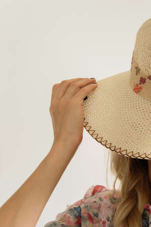 Crop view of attractive blond woman with elegant summer hat, white background with space for text