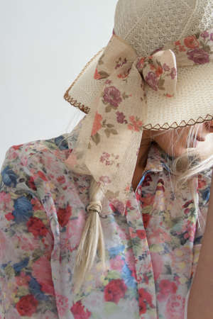 Crop view of attractive blond woman with elegant summer hat, white background with space for text