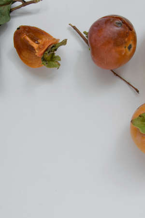 Top view of persimmon fruits on white background, healthy eating concept, space for textの写真素材