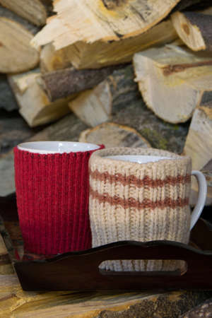 Tray with two cups of hot drink, on a wood pile, cozy seasonal conceptの写真素材