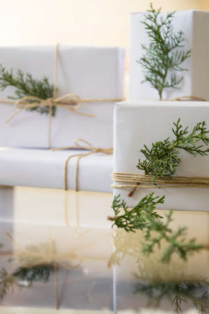 Elegant white handcraft gift boxes and fresh fir branches, seasonal celebration and eco-friendly...