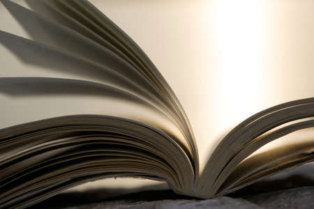 Open book with bright light on background, space for text